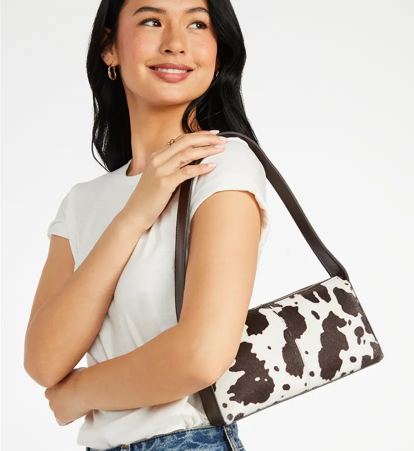 Model holding a large striped straw tote bag